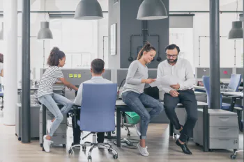 Menschen im Büro unter großen Lampenschirmen